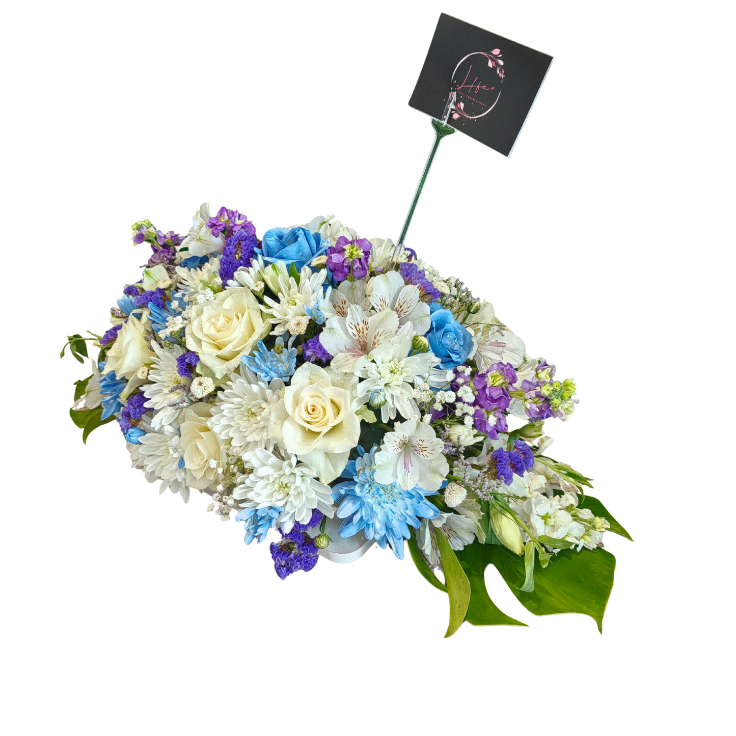 Divine Blooms centerpiece showcasing white florals and purple statice with delicate blue accents and fresh foliage in artistic harmony.