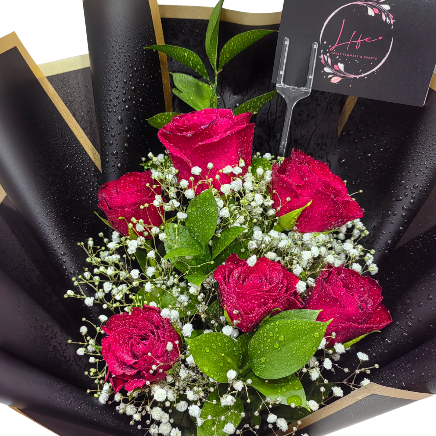 Hayat Flowers' Midnight Crimson-- a bouquet of 6 red roses, white gypsophila and single ruscus --luxuriously wrapped in black glossy paper with satin red ribbon finish.