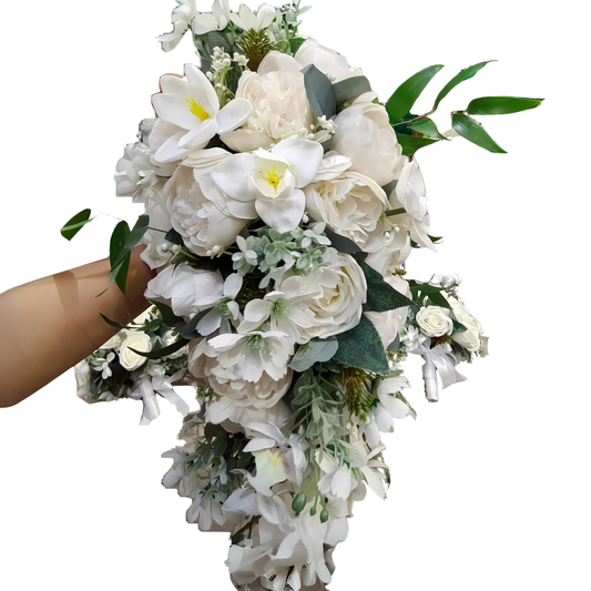 Handheld cascading white bridal bouquet featuring white peonies, roses, lorchids, and lush greenery with a teardrop shape, designed by Hayat Flowers and Events.
